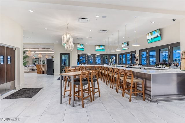 interior space with a high ceiling, a chandelier, and indoor bar