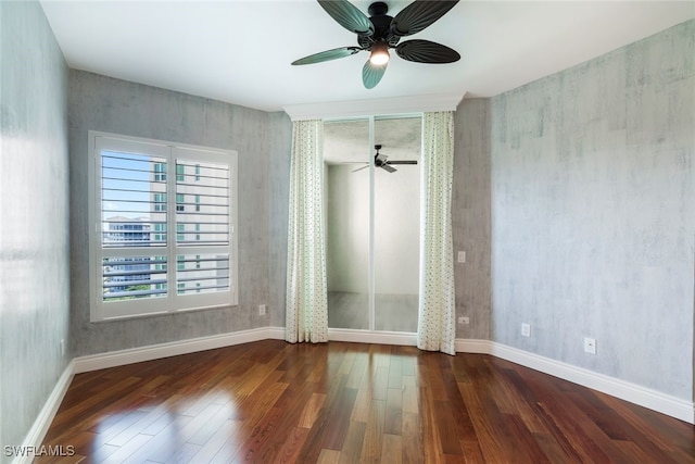 empty room with a ceiling fan, wood finished floors, and baseboards