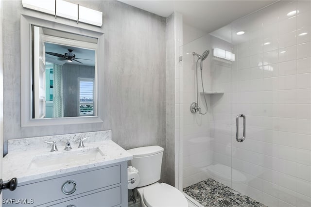 bathroom featuring ceiling fan, walk in shower, vanity, and toilet