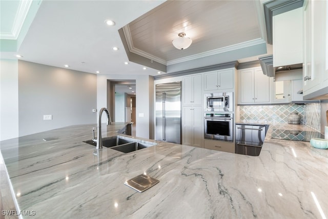 kitchen featuring a sink, light stone counters, tasteful backsplash, crown molding, and built in appliances