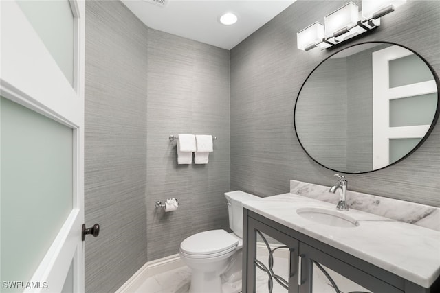 bathroom with tile walls, vanity, and toilet