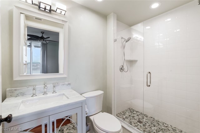 bathroom featuring vanity, toilet, ceiling fan, and an enclosed shower