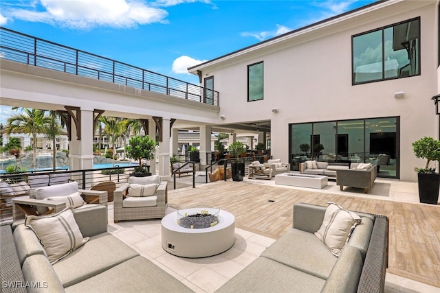 view of patio / terrace featuring an outdoor living space with a fire pit and a balcony