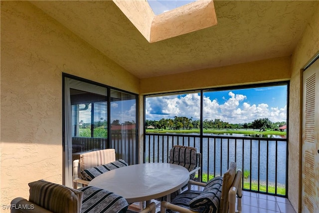 sunroom with a water view, plenty of natural light, and lofted ceiling