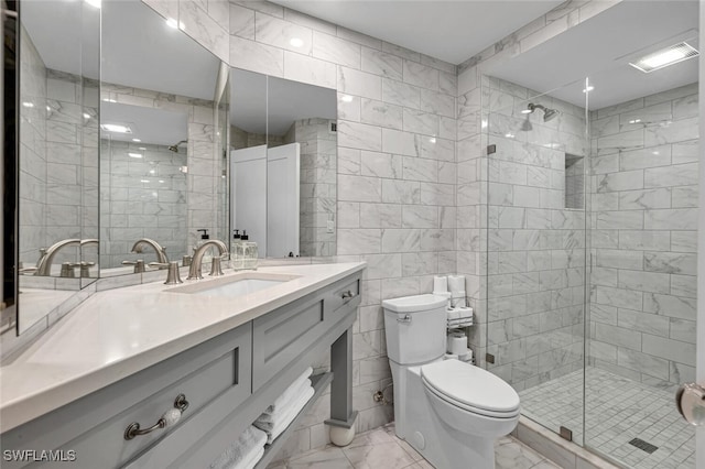 bathroom with vanity, tile walls, toilet, and a shower with door