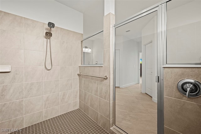 bathroom featuring tile patterned flooring and a tile shower