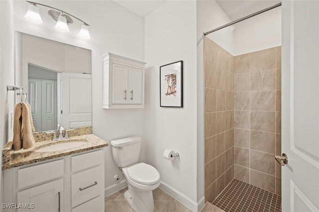 bathroom with toilet, tile patterned flooring, tiled shower, and vanity