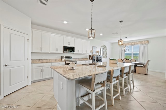 kitchen featuring stainless steel appliances, visible vents, a sink, and light tile patterned floors