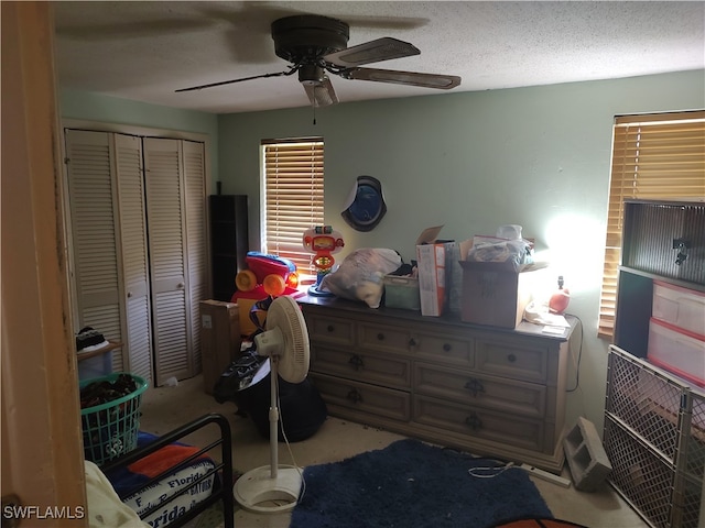 bedroom with a closet, ceiling fan, and a textured ceiling