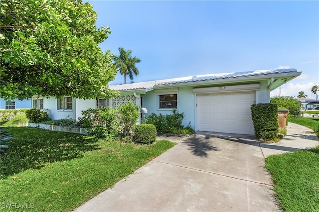 view of front of property featuring a front yard and a garage