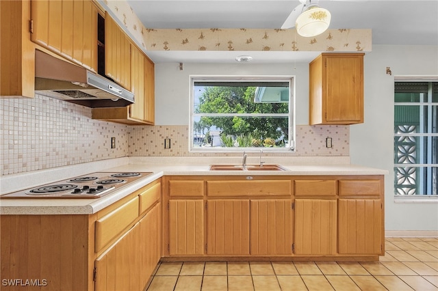 kitchen featuring sink, white electric stovetop, backsplash, light brown cabinets, and light tile patterned floors