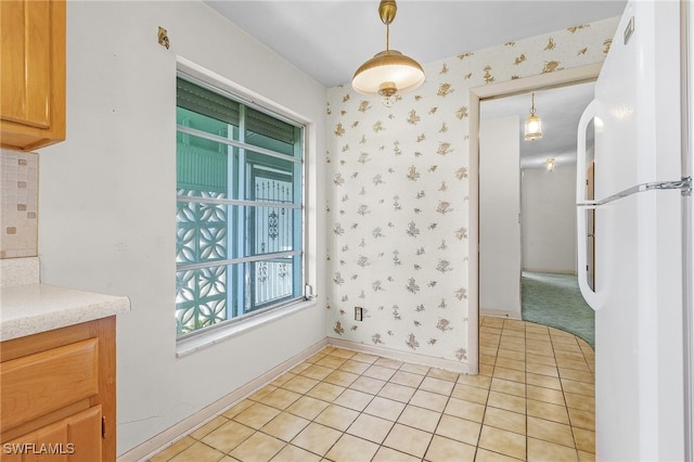 kitchen featuring pendant lighting, white refrigerator, and light tile patterned flooring