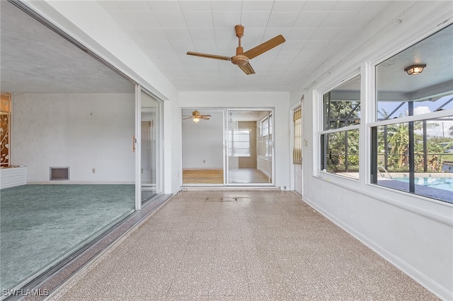 unfurnished sunroom featuring ceiling fan