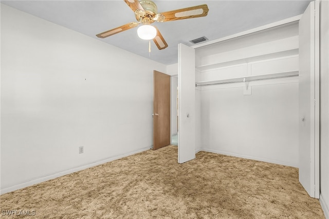 unfurnished bedroom with ceiling fan, light colored carpet, and a closet