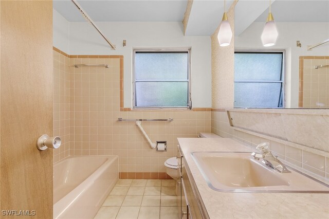 full bathroom featuring tiled shower / bath, vanity, toilet, and tile patterned floors