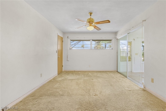 carpeted spare room featuring ceiling fan