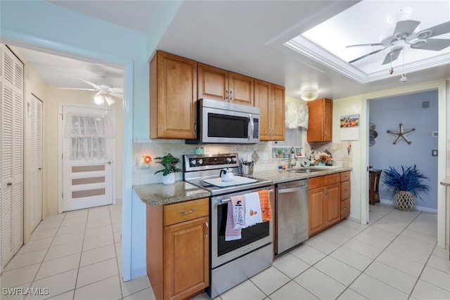 kitchen with sink, tasteful backsplash, light tile patterned floors, ceiling fan, and appliances with stainless steel finishes