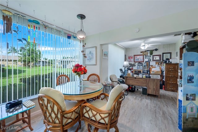 dining space featuring wood-type flooring and ceiling fan