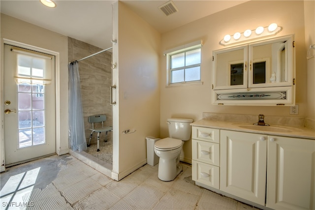 bathroom featuring a healthy amount of sunlight, a shower with curtain, vanity, and toilet