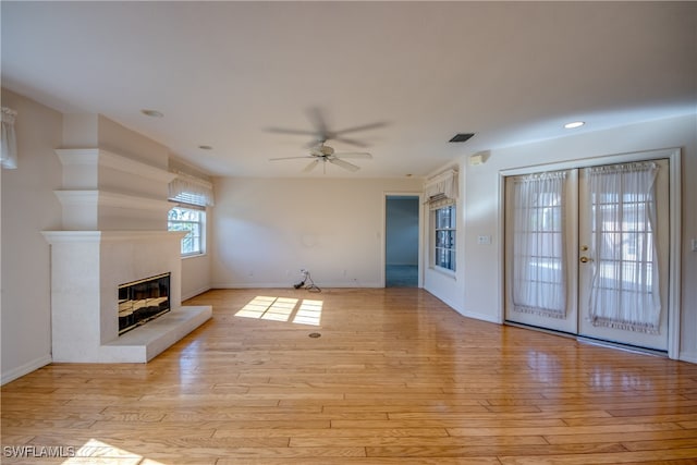 unfurnished living room featuring light wood-type flooring, ceiling fan, and french doors