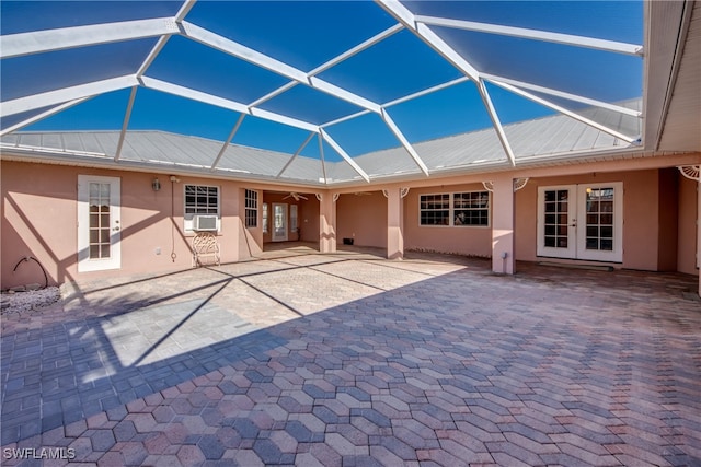 back of house with glass enclosure and a patio area