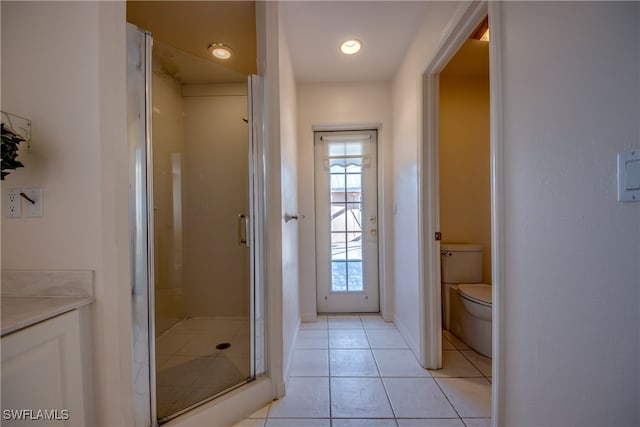 bathroom with tile patterned floors, walk in shower, vanity, and toilet