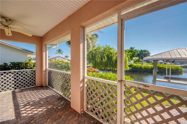 wooden deck featuring ceiling fan and a water view