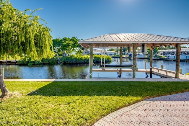 view of dock featuring a water view and a yard