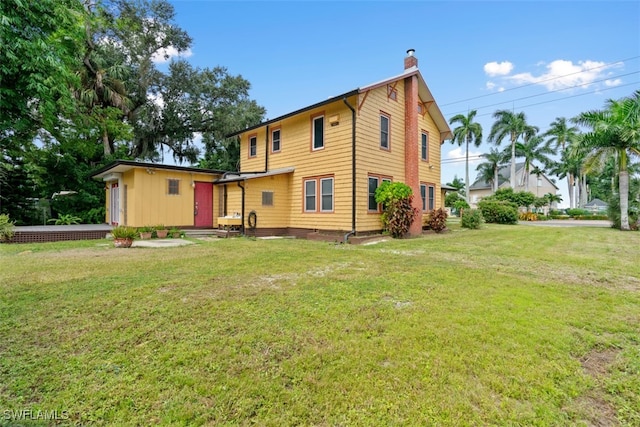 rear view of property with a lawn