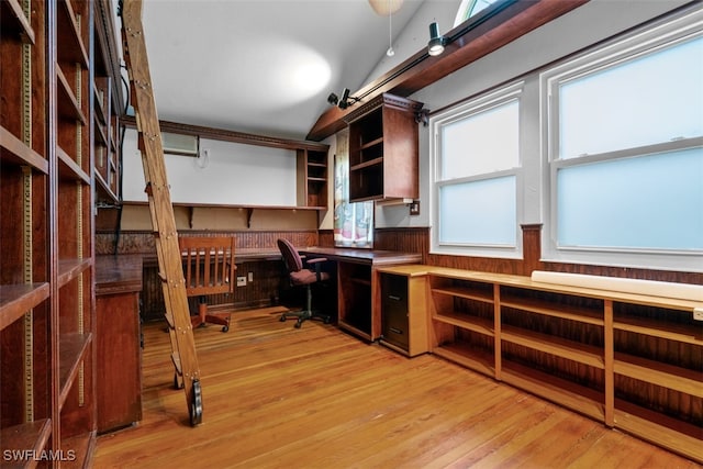 office area featuring built in desk, light wood-type flooring, and vaulted ceiling