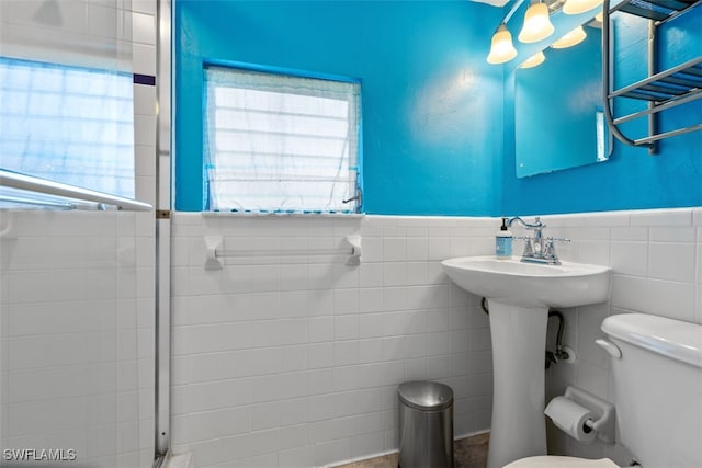 bathroom with tile walls and toilet