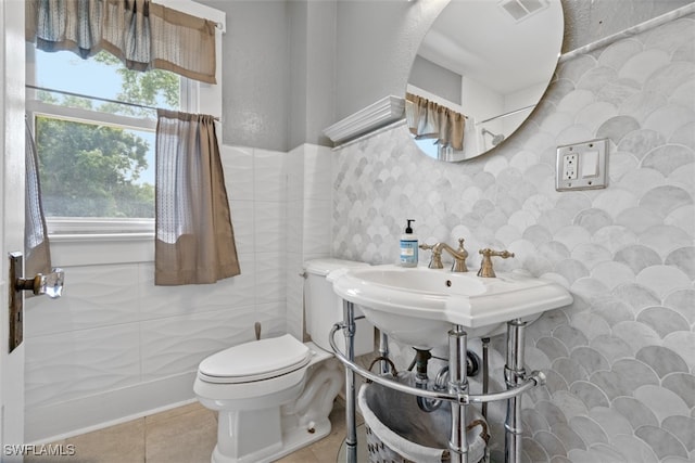 bathroom with tile walls, tile patterned flooring, and toilet