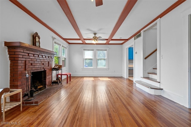 living room featuring a fireplace, beamed ceiling, ceiling fan, hardwood / wood-style flooring, and ornamental molding