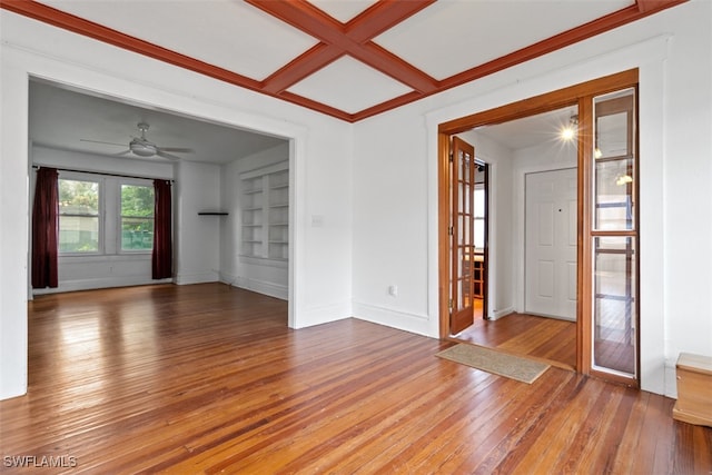 unfurnished room featuring ceiling fan, hardwood / wood-style flooring, built in features, and coffered ceiling