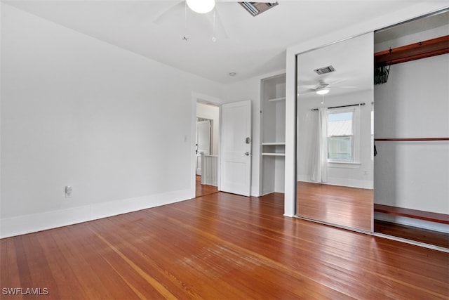 unfurnished bedroom with wood-type flooring, a closet, and ceiling fan