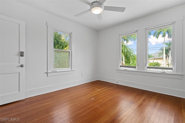 unfurnished room with wood-type flooring, ceiling fan, and a wealth of natural light