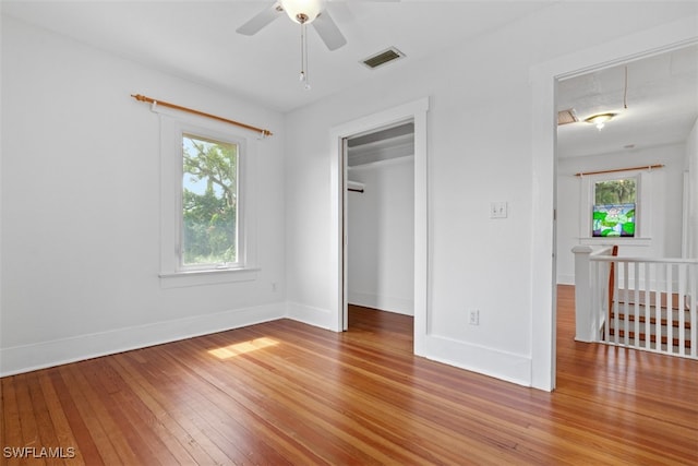 unfurnished bedroom with ceiling fan, a closet, and hardwood / wood-style floors