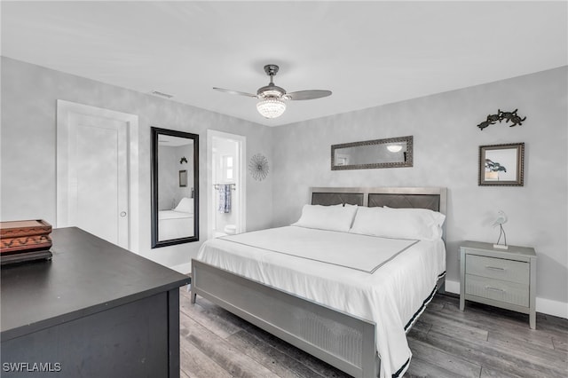 bedroom with dark hardwood / wood-style floors, ensuite bathroom, and ceiling fan