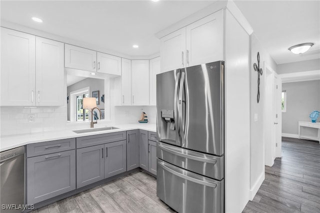 kitchen with light hardwood / wood-style floors, gray cabinets, appliances with stainless steel finishes, and sink