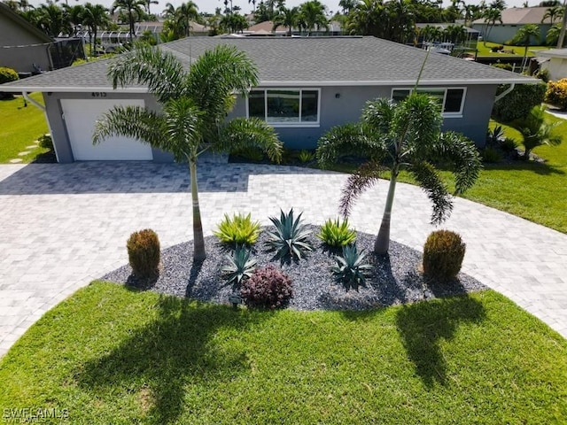 single story home featuring a garage and a front lawn