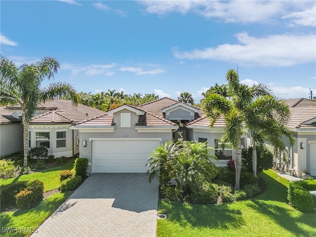 28777 Montecristo Loop, Bonita Springs, FL 34135 - mediterranean / spanish-style home with a tiled roof, a front lawn, stucco siding, an attached garage, and decorative driveway