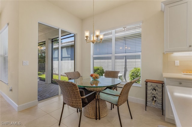 dining room featuring a healthy amount of sunlight, light tile patterned floors, and a chandelier