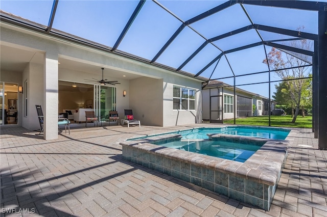 view of swimming pool featuring an in ground hot tub, a lanai, ceiling fan, and a patio area