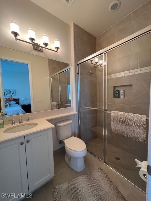 bathroom featuring vanity, a shower with shower door, toilet, and tile patterned flooring