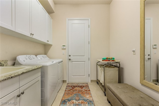 laundry room featuring cabinets, light tile patterned floors, and washing machine and dryer