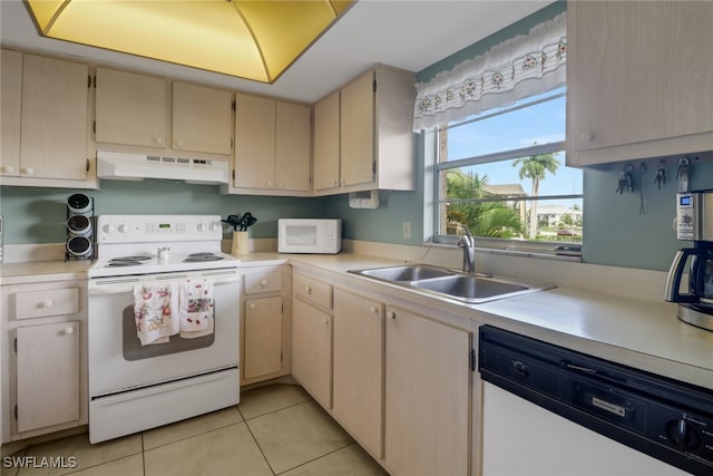 kitchen featuring white appliances, light tile patterned floors, and sink