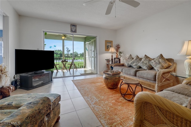 living room with ceiling fan, a textured ceiling, and light tile patterned floors