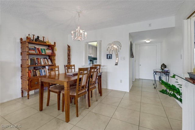 tiled dining room featuring a chandelier and a textured ceiling