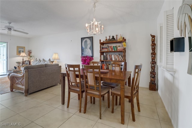 dining room with light tile patterned flooring, ceiling fan with notable chandelier, and a textured ceiling