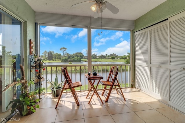 sunroom / solarium featuring a water view and ceiling fan